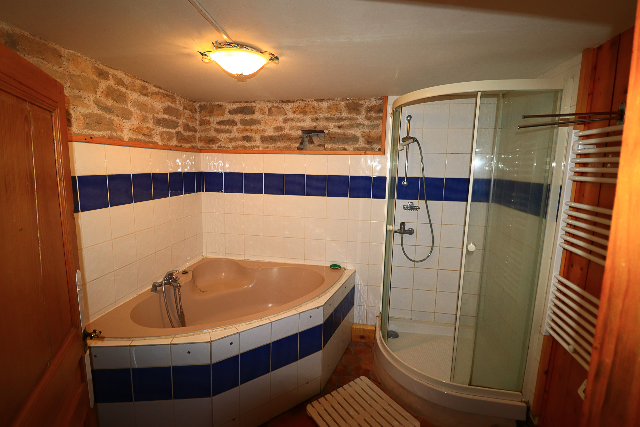 Salle de bain avec baignoire et douche d'angle